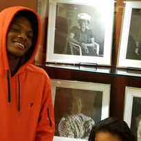 African American male and child standing in front of a Black History exhibit