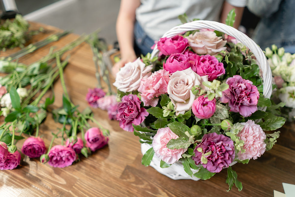Woman florist create flower arrangement in a wicker basket Beautiful bouquet of mixed flow