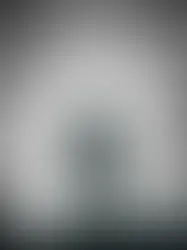 A man stands central holding a flashlight, a light emanates from behind him highlighting his silhouette. To the left of tentacles reach from the darkness, to the right of him a dark entity looms towards him with clawed fingers outstretched. 