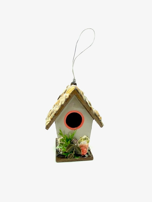 Thumbnail: Front view of soft grey cottagecore mini birdhouse with the roof made of shells and pops of coral.