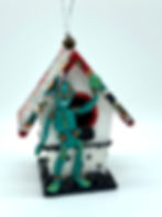 Front view of mini birdhouse with a teal skeleton on the front and a red colorful day of the dead roof.