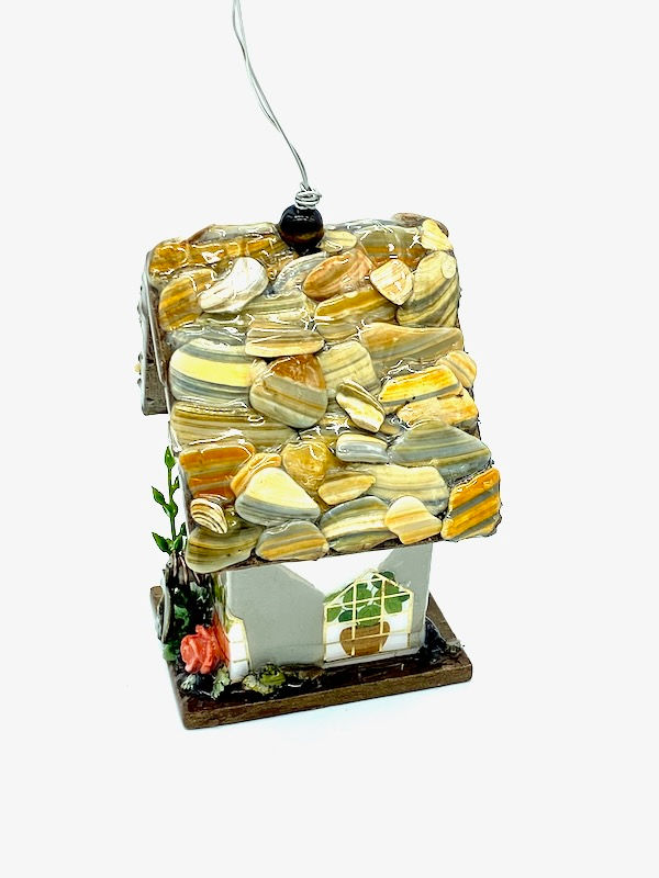 Thumbnail: Side view of soft grey cottagecore mini birdhouse with the roof made of shells and pops of coral.