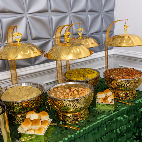 Golden food display with various dishes on a green table, festive occasion.