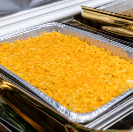 Mac and cheese in a silver pan ready for serving at a buffet.