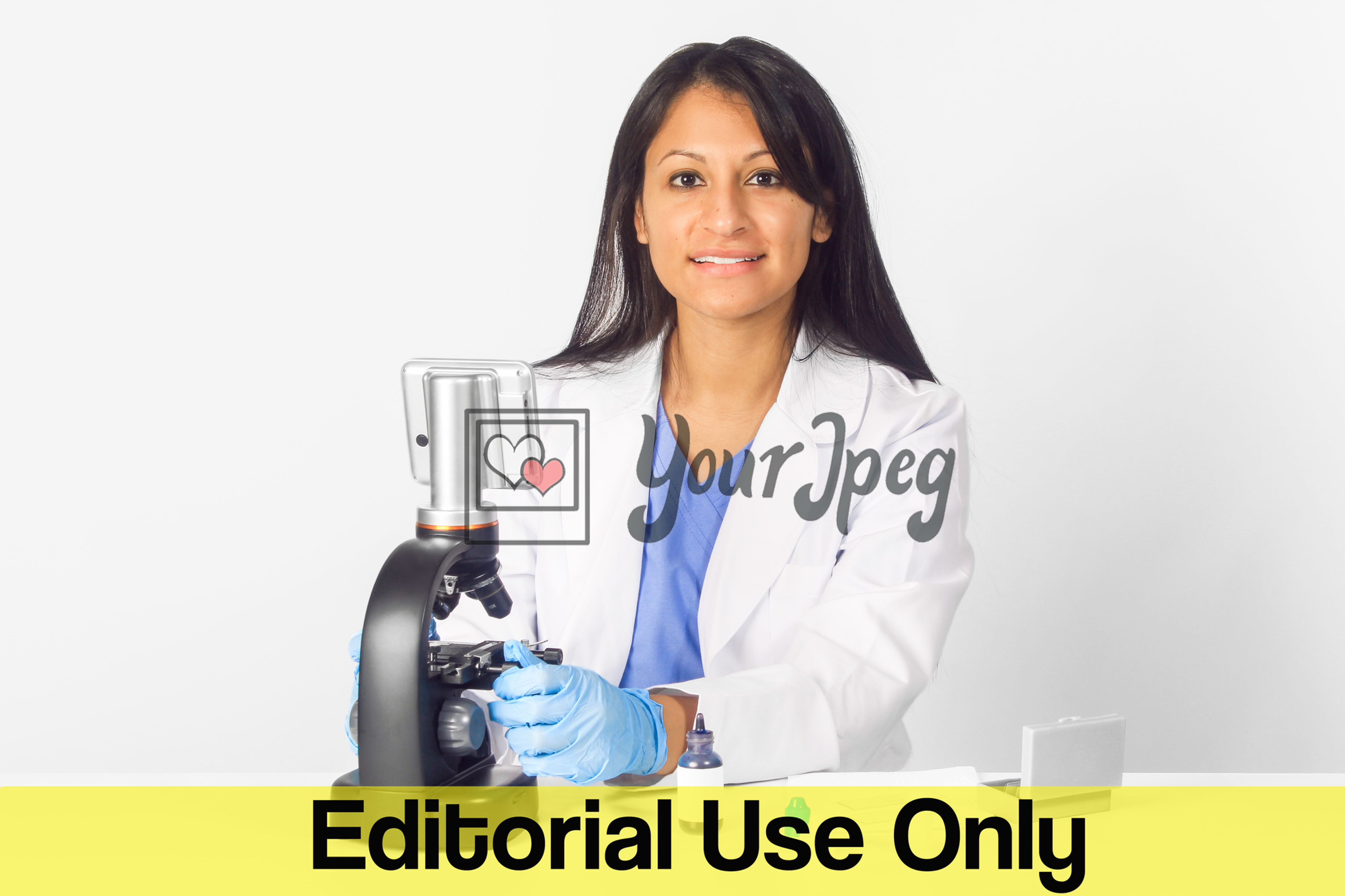 Female Doctor Wearing Gloves While Using Microscope