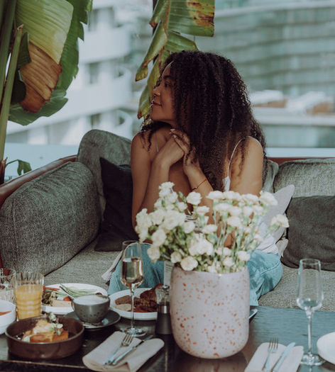 Woman enjoys breakfast on the rooftop terrace of the Aurora Rooftop Bar.