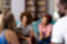 Smiling people sitting in a circle at group therapy