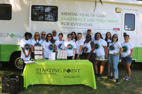Starting Point staff members at The Glow Up community event in front of the Mobile Mental Health Clinic