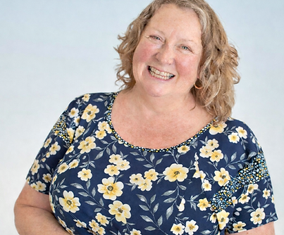 Smiling woman in floral blouse.png