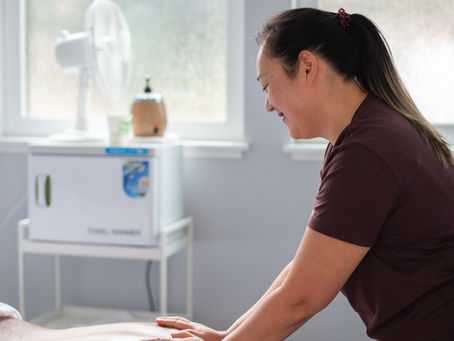 Kiyomi, registered massage therapist (RMT) at Broadmoor Chiropractic Massage Naturopathy, providing a personalized massage session focused on relieving tension and supporting wellness.