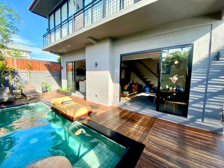 Sunny day at Zen Villas in Bali: Enjoy the wooden deck, swimming pool, and parking area, creating a tranquil outdoor haven."