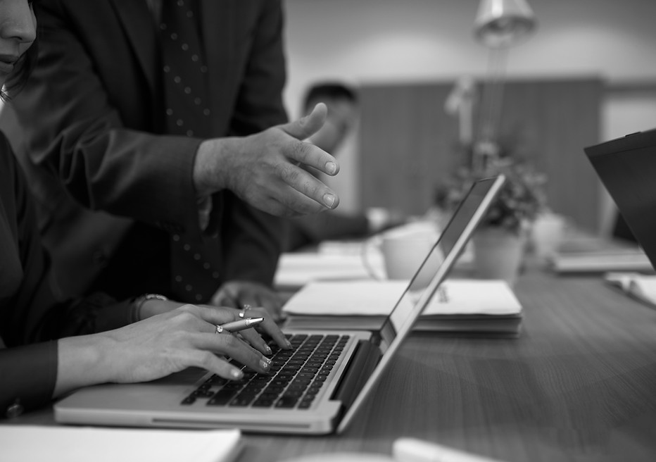 mujer-irreconocible-trabajando-en-la-computadora-portatil-en-la-oficina-y-el-hombre-parado