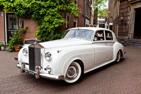 White vintage car, Rolls-Royce, as a bridal car, parked in Amsterdam after the wedding ceremony.
