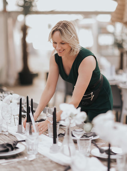Anne-Martine Speelman wedding planner stylt een tafel met witte orchideeën en zwarte kaarsen tijdens een strandhuwelijk in Noordwijk