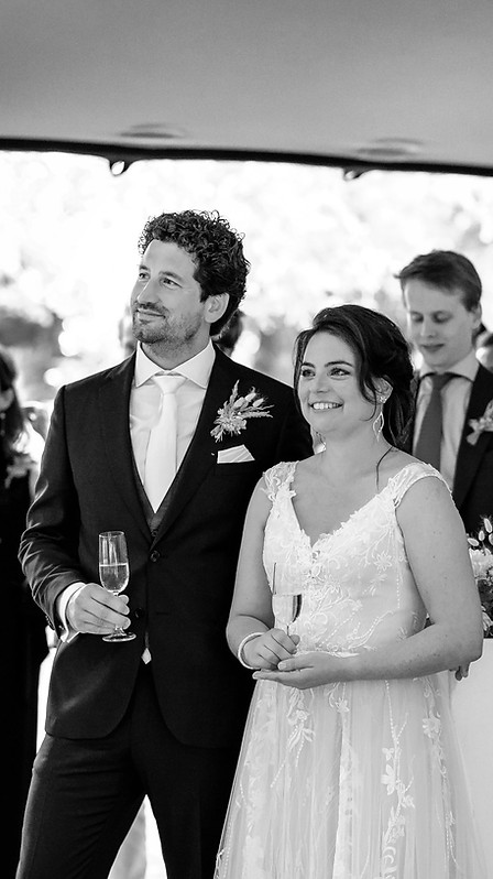 Bruid en Bruidegom tijdens toost met champagne op tuinhuwelijk in Wassenaar. Planning Anne-Martine Wedding Planner.