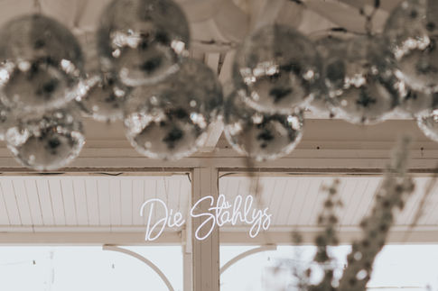 Stylish, luxurious decoration with disco balls and a custom-made neon sign with the bride and groom's name.