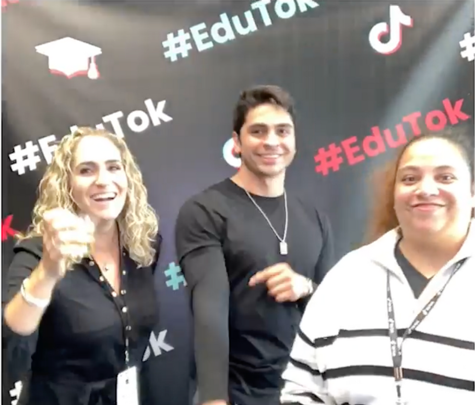 Three people smiling at camera with a #EduTok step and repeat behind them.