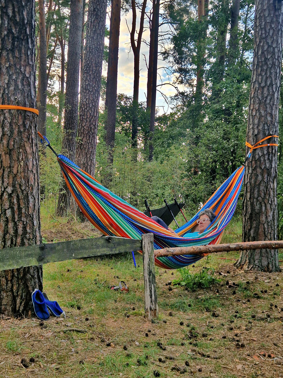 Monika relaxing in a colorful hammock among the pines at Lake Wędromierz.