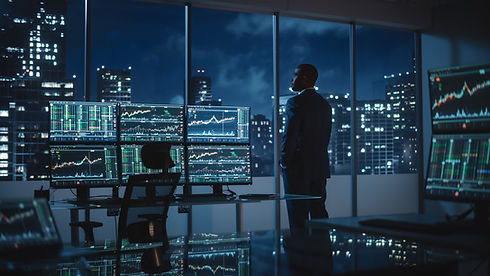 Successful Businessman Looking Out of the Window on Late Evening. Modern Hedge Fund Office