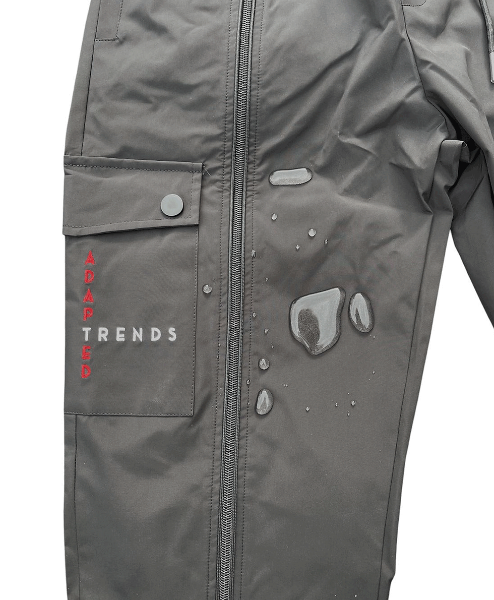 Image showing adapted trends waterproof cargo trousers with large pocket and zips and splashes of water on a white background