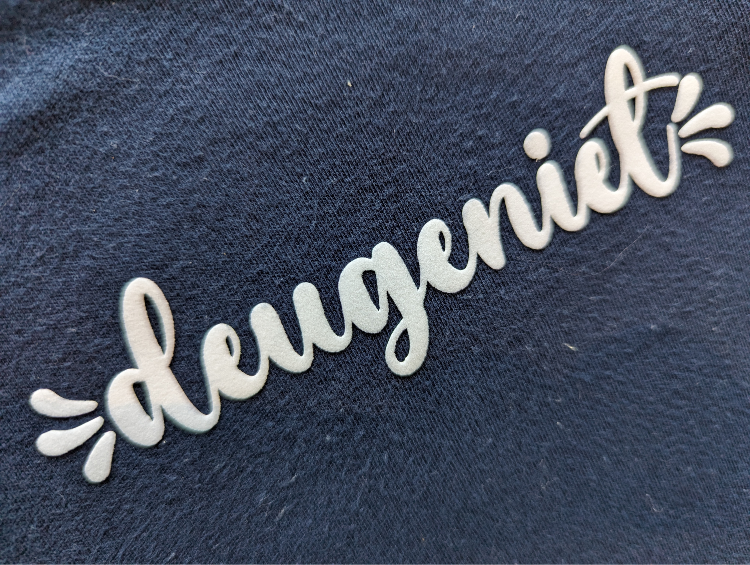 Close-up van de witte velours bedrukking van het deugeniet ontwerp.