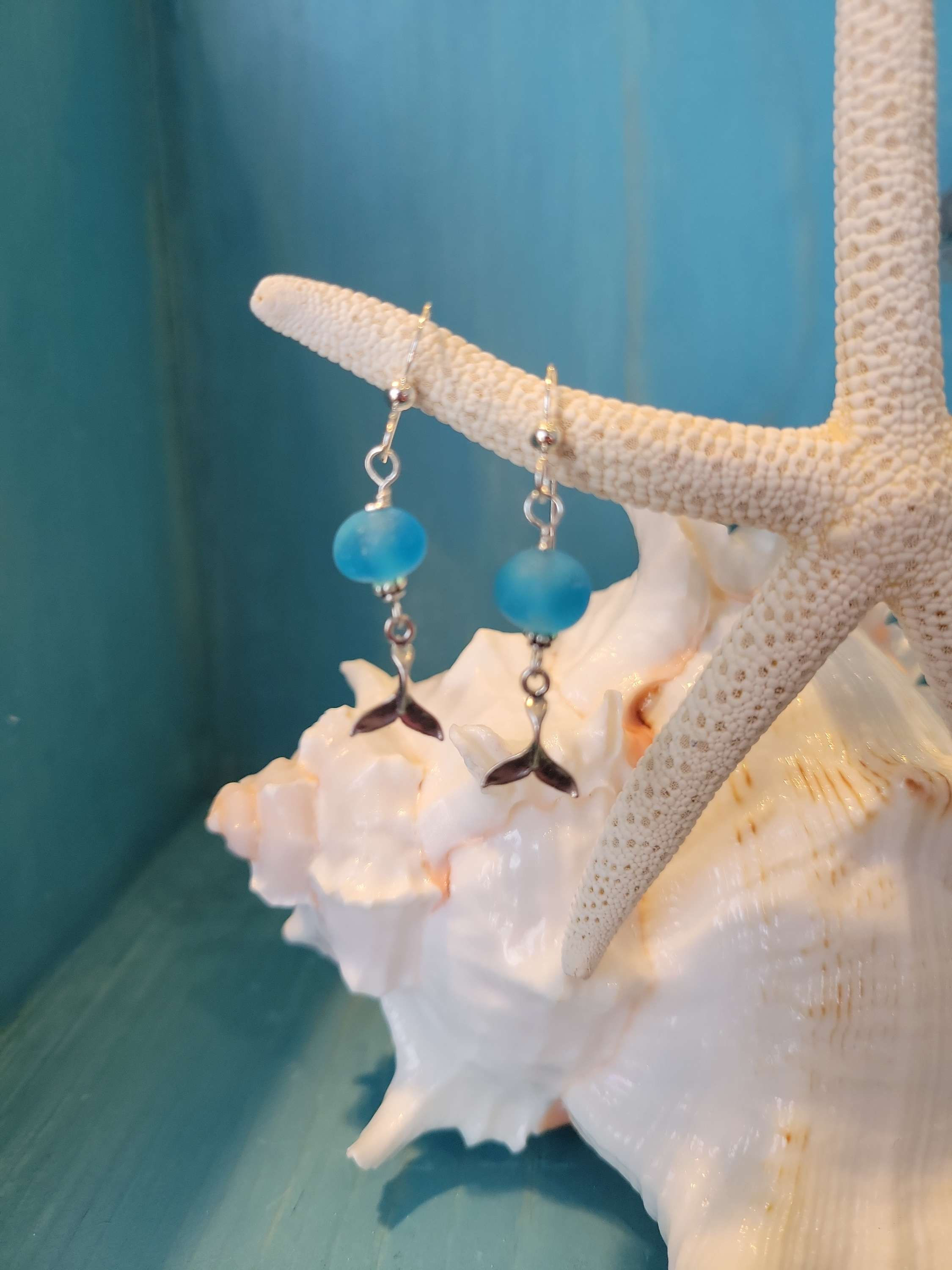 Bright turquoise sea glass with sterling silver whale tail. 