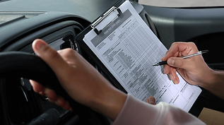 Driver filling out a vehicle safety checklist in a van