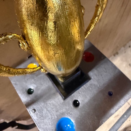 a gold metal sculpture by John Latell