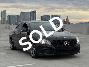 Mercedes Benz CLA 250 black on a parking garage roof, with las vegas in the background