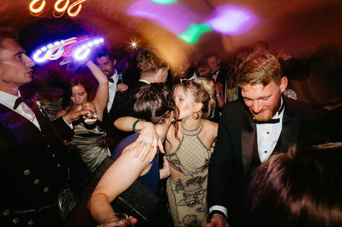 Dancing and embracing wedding guests with festive lights and Wedding DJ Scotland.