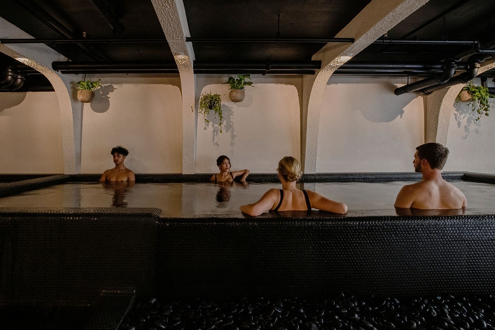 Four people sitting in a black tiled pool