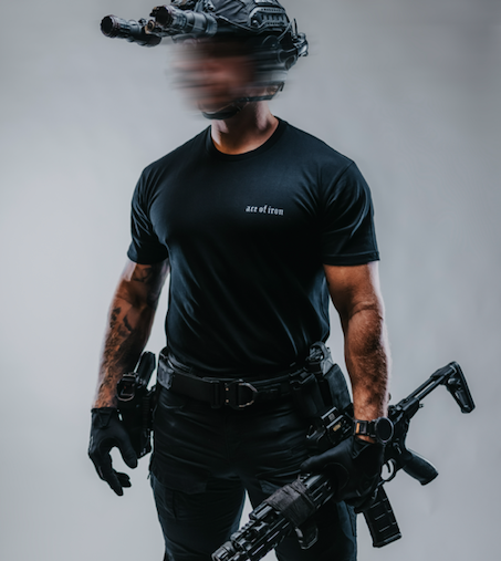 Man in grey Ace of Iron Apparel shirt aiming a sniper rifle, with a smooth grey backdrop that underscores focus and resilience.