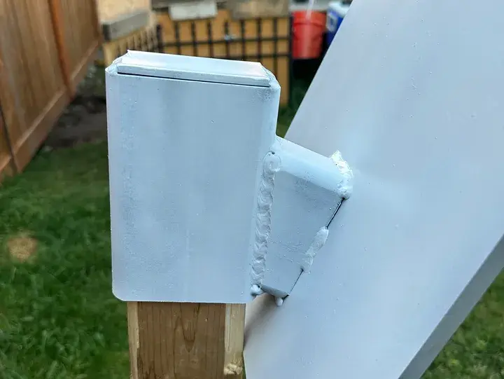 Welded metal bracket on wooden post