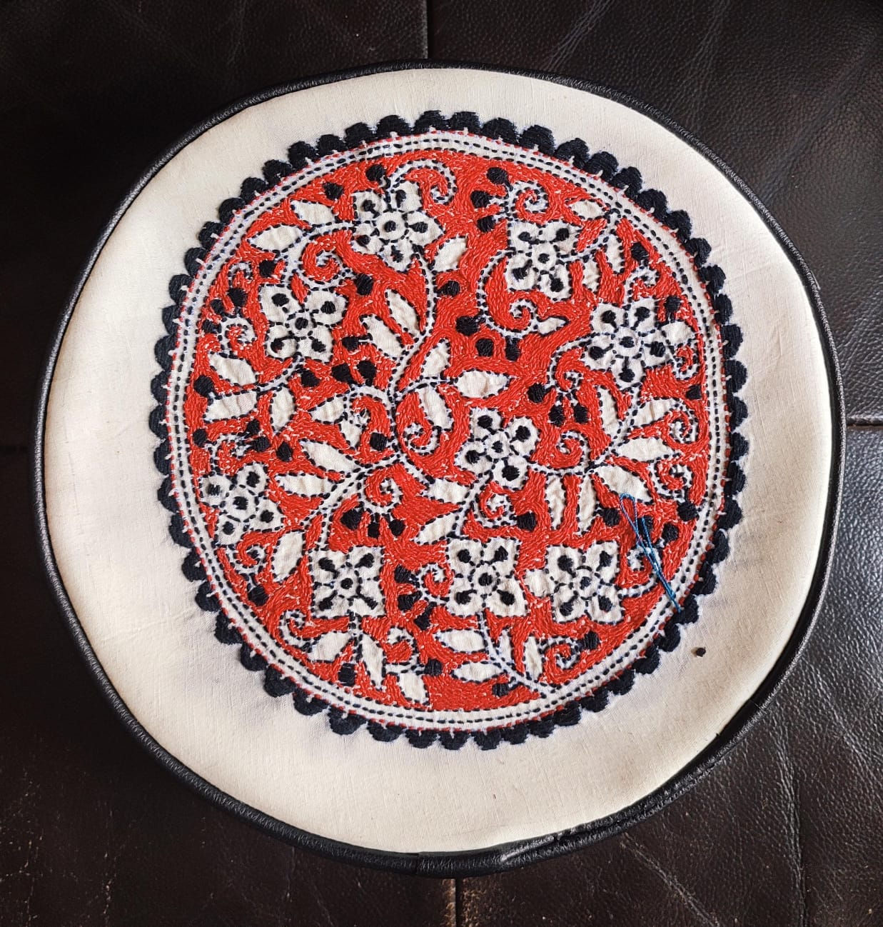 Bag: White circular cotton and leather sling bag with thread-work in black, red