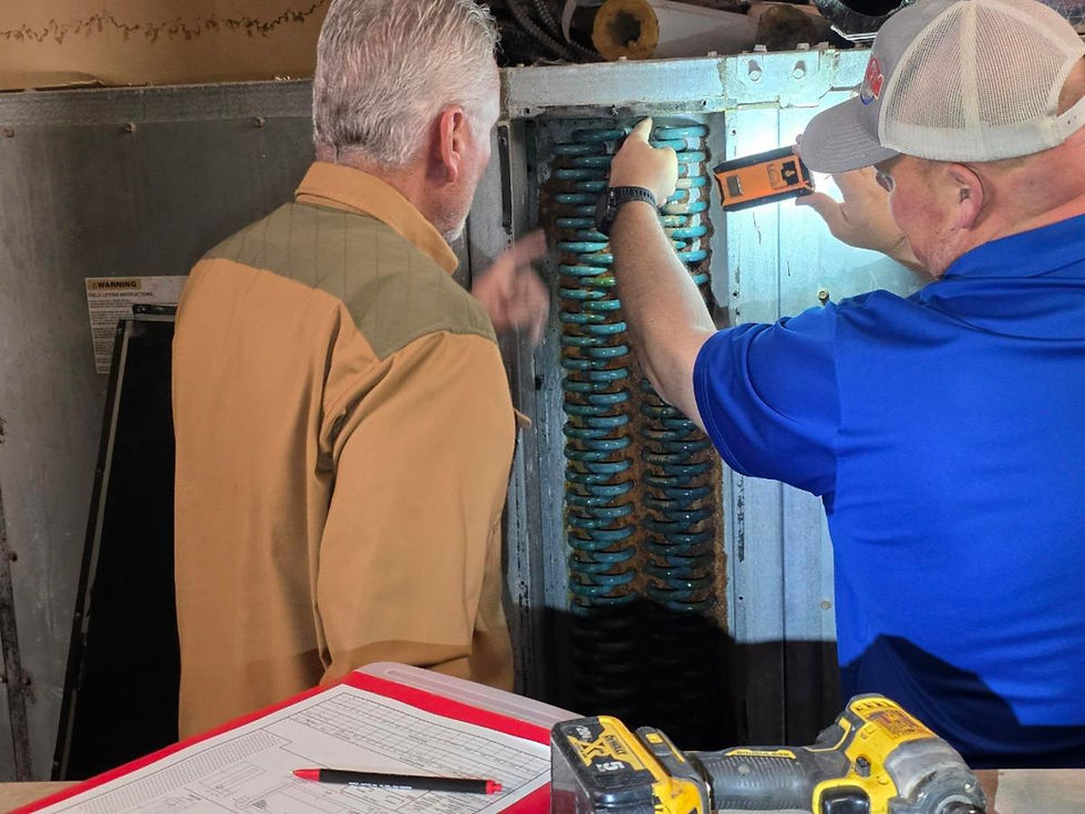 Two men inspect an HVAC system. One points, the other uses a tool. Notepad with diagrams in foreground, setting is industrial.