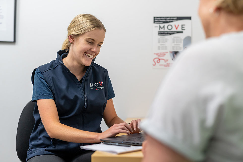 Physio at computer listering and helping client with hypermobility