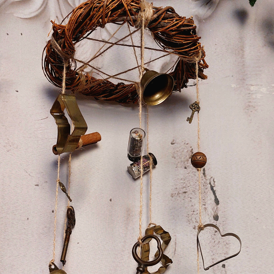 zoom sur la couronne de saule tressée artisanalement à laquelle sont suspendues les clochettes de sorcière