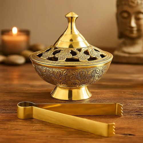 Encensoir rituel en laiton doré avec couvercle ajouré et pince, posé sur une table en bois pour fumigation d'encens naturels