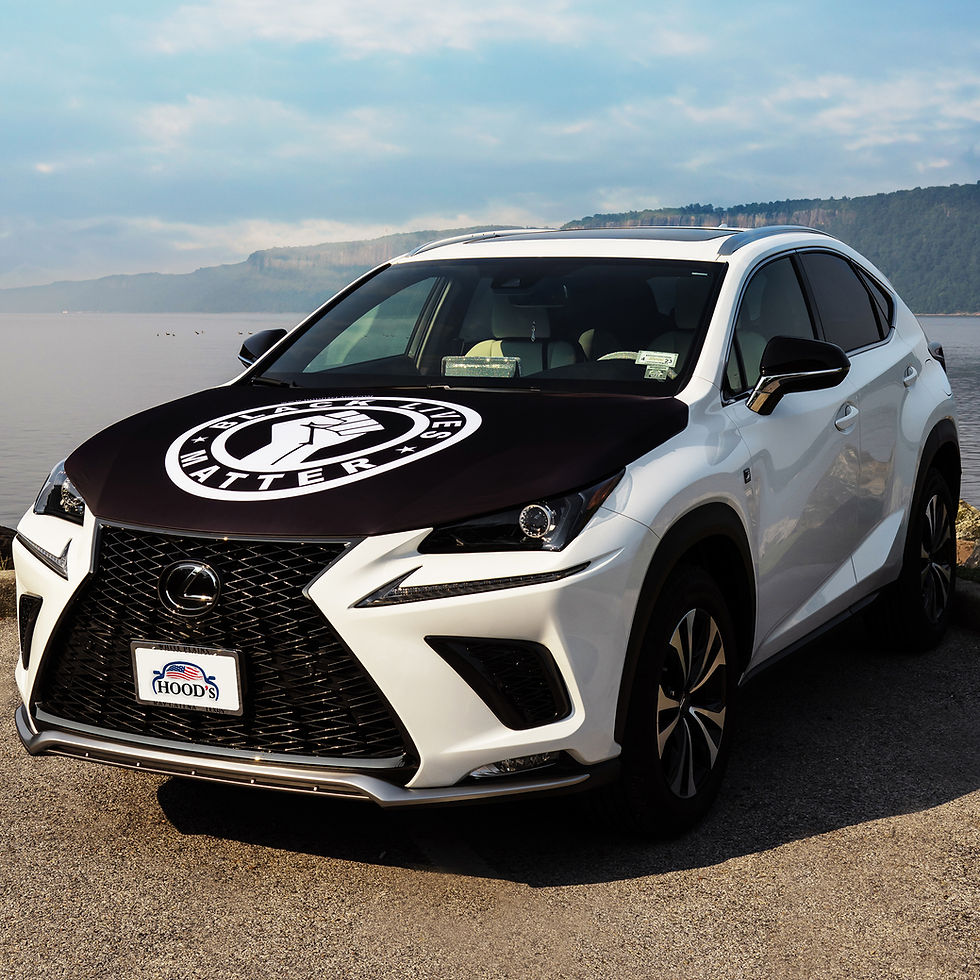 White SUV with Black Lives Matter (BLM) hood cover featuring raised fist logo near water