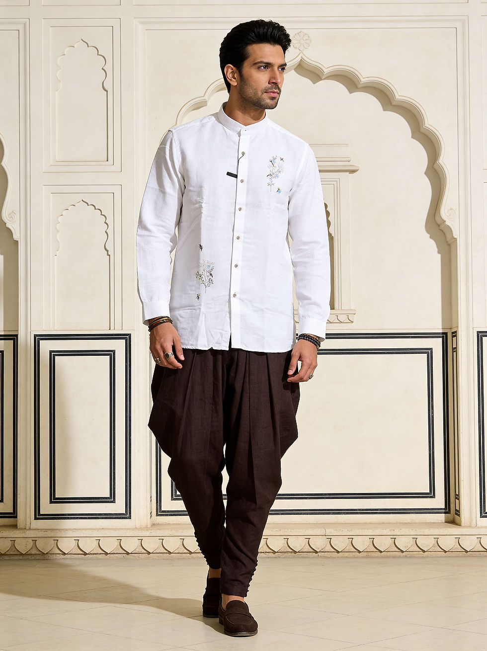 Man wearing white band-collar shirt and brown pleated pants