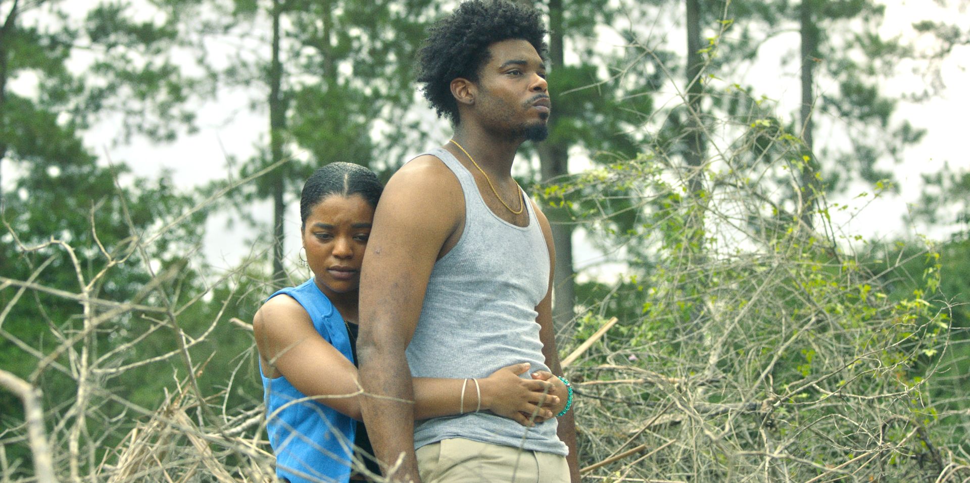 Nia and Kenny stand close together among the trees in rural Mississippi.