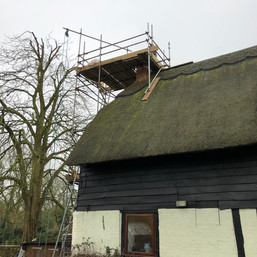 Scaffold around a chimney stack on a thatched property.