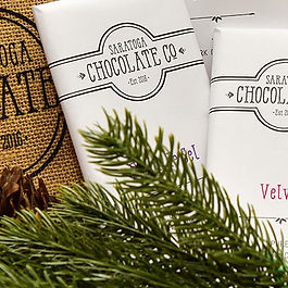 a burlap bag with gourmet chocolate bars and pine boughs