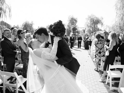 Bride and Groom kiss during the wedding ceremony at Niagara On the Lake's Pillar and Post Hotel by Little Blue Lemon
