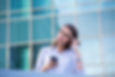 Woman wearing glasses looking puzzled and weary with coffee cup in wone hand and phone in another.