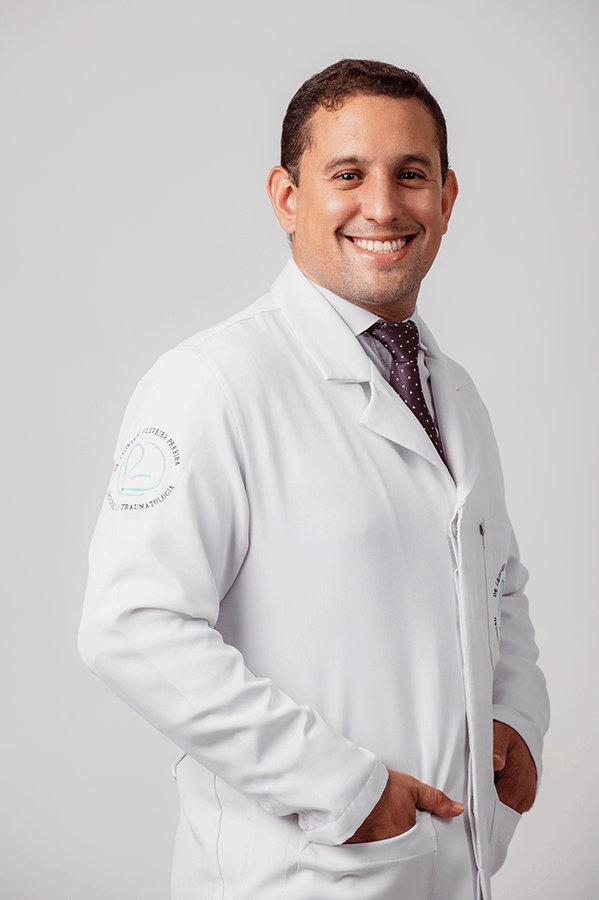 Foto do Dr Leonardo Oliveira de jaleco e sorrindo