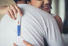 casal-feliz-sorrindo-depois-de-descobrir-teste-de-gravidez-positivo-no-quarto.jpg