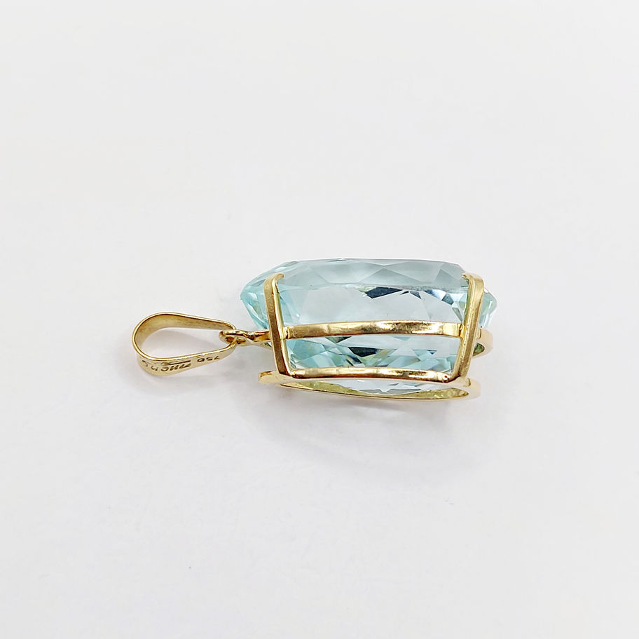 Pendentif en or jaune avec une grande aigue-marine, fond blanc, bijou précieux.