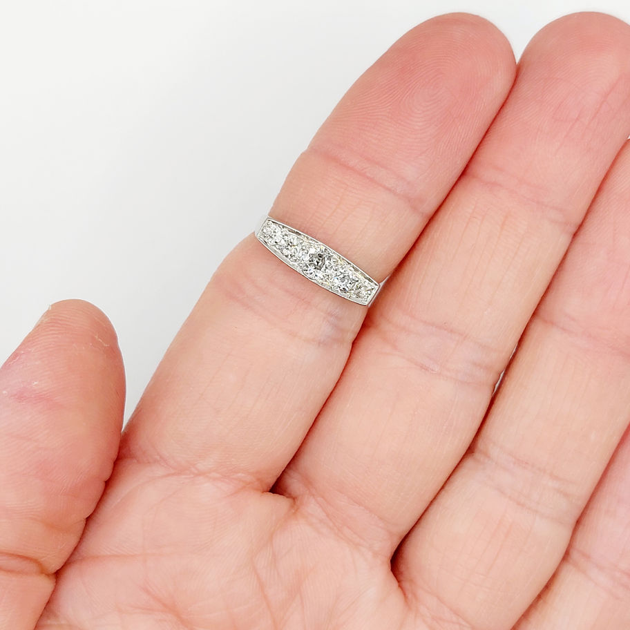 Main de femme tenant une bague. Bague marquise antique 18k et diamants, 1,75 carat.