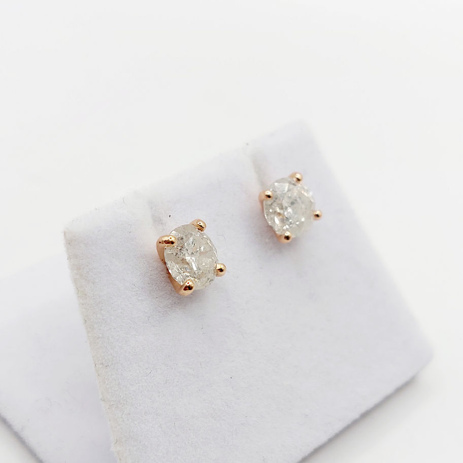 Boucles d'oreilles en or rose avec diamants brillants sur présentoir blanc